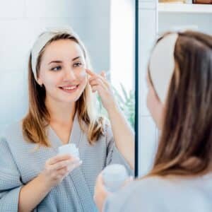 mulher aplicando protetor solar para ficar em casa